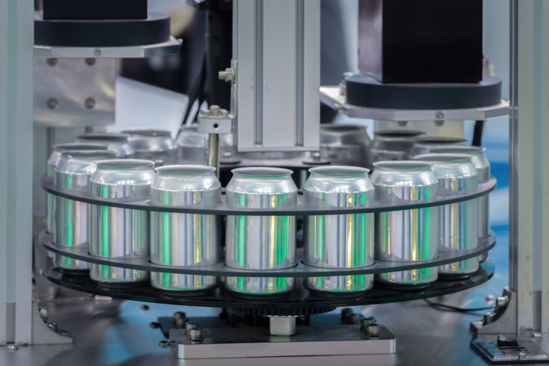 empty new aluminum cans for drink process are moving in factory line on conveyor belt machine at beverage manufacturing. food and beverage industrial business concept.
